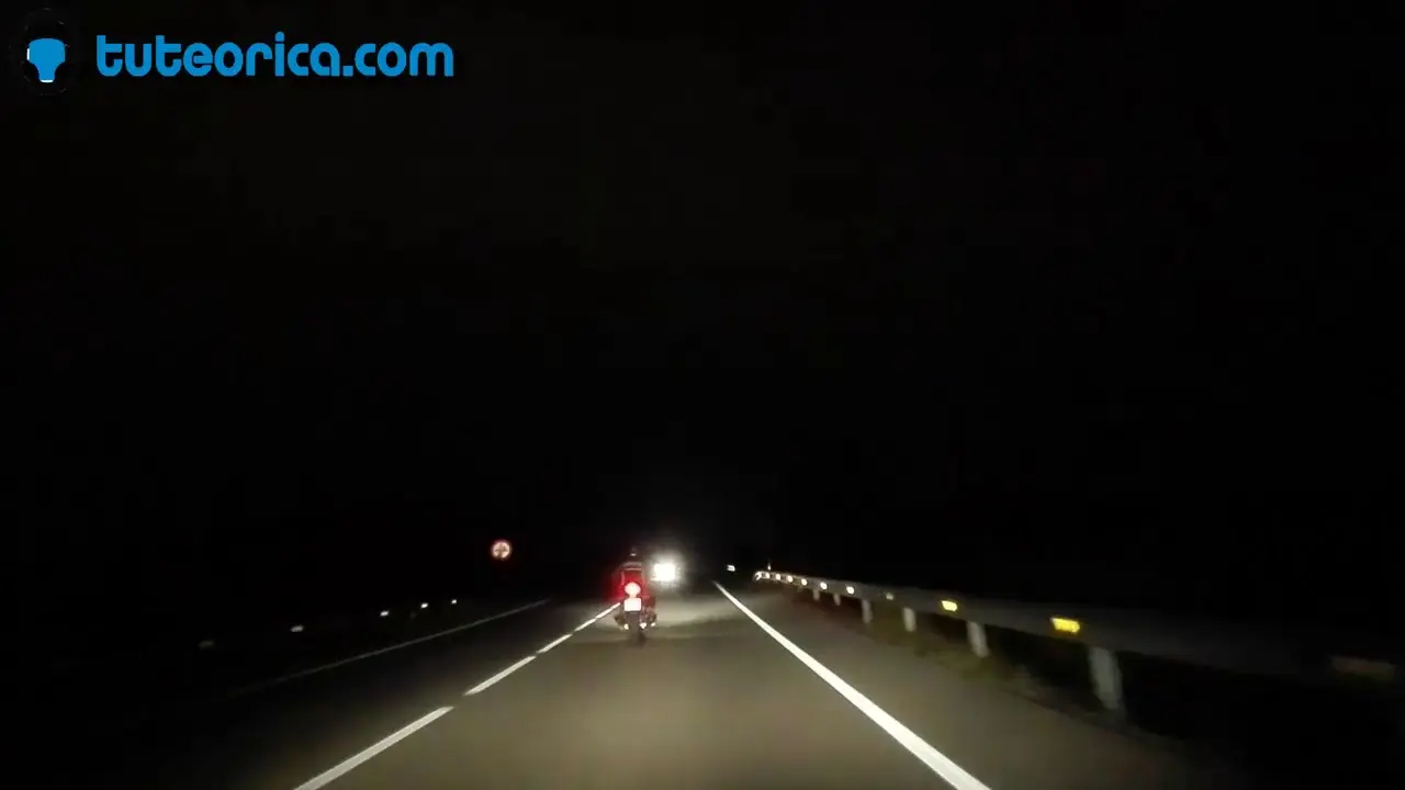 Motorista de noche por carretera convencional