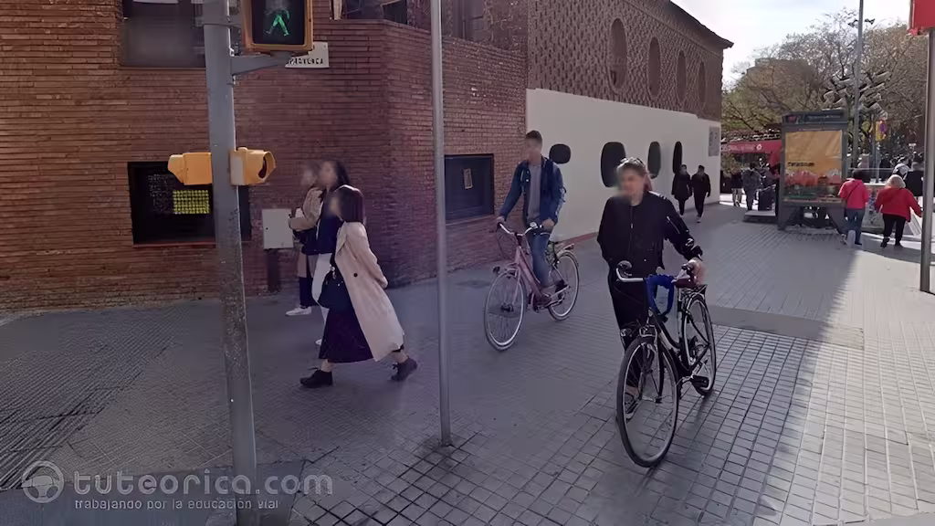 Peaton empuja una bicicleta por la acera