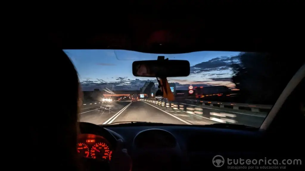 Conductora en el interior del vehículo en una carretera de noche
