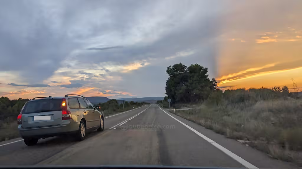 adelantamiento en carretera convencional al atardecer
